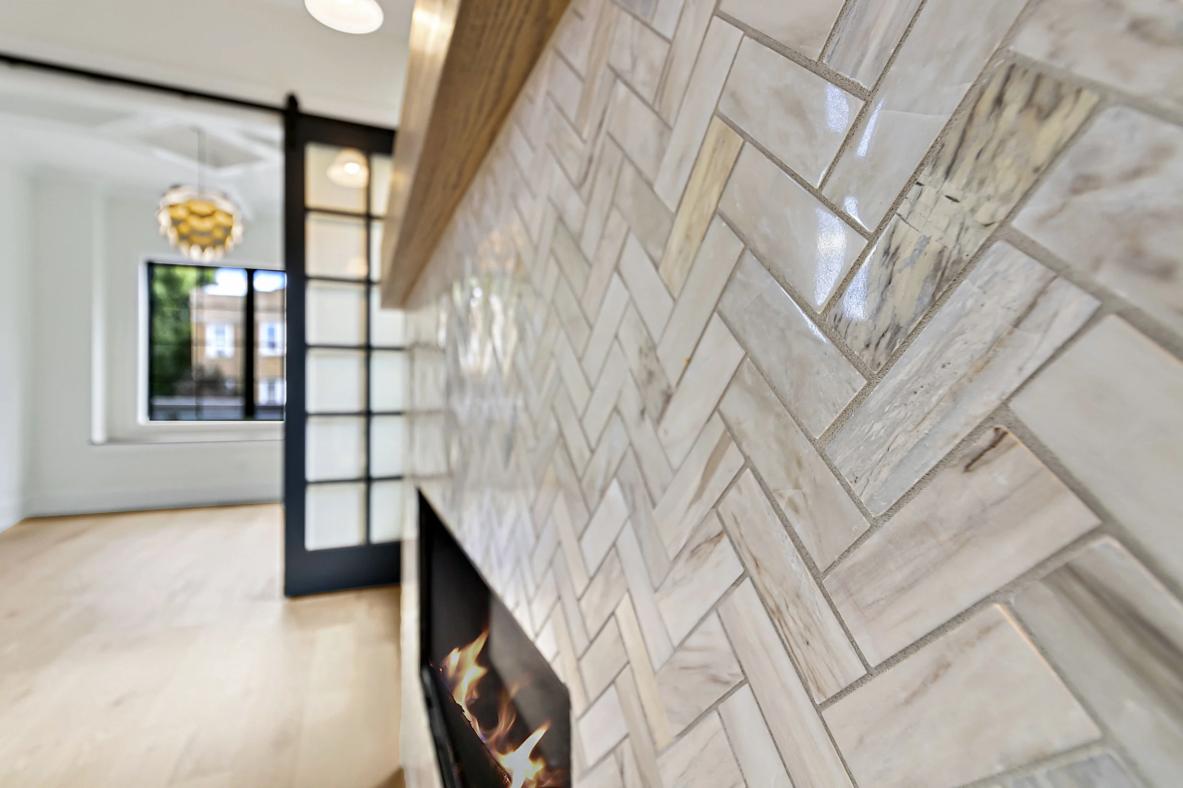 Close-up of a herringbone tile fireplace surround